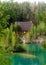 Wooden house with a satellite dish standing in the woods in the pine trees on the shores of stone lake.