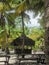 Wooden house, a table, benches on the sand.