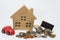 Wooden house toy, red car, small black board and Thai baht coin with white background and selective focus