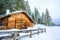 Wooden house in winter mountain landscape. Cottage / Hut in snowy mountains. Travel destination for recreation