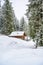 Wooden house in winter mountain landscape. Cottage / Hut in snowy mountains. Travel destination for recreation