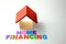 Wooden house with the words "home financing" on white background. Real estate planning and financing concept.