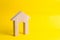 Wooden house on a yellow background. Concept of buying and selling housing, building a house. Rent of apartments. Realtors. Real e