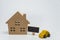 Wooden house, yellow car toy and small black board with white background and selective focus