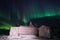 Wooden house, yurt hut on the background the polar Northern aurora borealis lights