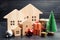Wooden houses and Christmas tree. Christmas Sale of Real Estate. New Year discounts for buying house. Purchase apartments at a low