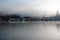 Wooden houses at morning fog on lake Konigsee