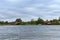 Wooden houses on the shore of the reservoir, farm buildings on the river