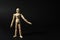 Wooden human model on black, space for text. Mini mannequin