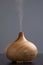 wooden humidifier for essential oils, with steam smoke, gray background