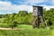 Wooden hunting watchtower in the Czech landscape. Countryside in the Czech Republic. Wild game hunting.