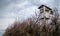 Wooden hunting watchtower under cloudy autumn sky