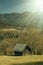 Wooden hut on animal farm.Mountains in background.