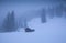 Wooden hut in foggy alpine forest