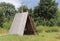Wooden hut in the green for a holiday in the hike. Primitive shelter of rain and sun for scouts, hunters and shepherds. Romance of