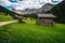 Wooden huts and flowery green fields, San Nicolo valley, Dolomites