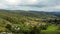 Wooden huts in the valley among mountains and green forests. Picturesque natural landscape. Aerial drone view, crane shot techniqu