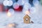 Wooden icon of house with hole in form of heart with red home Christmas decor and blurred bokeh background in daylight