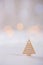 Wooden icon of triangular Christmas tree with garland lights on