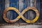 a wooden infinity symbol against an old rustic wall