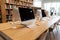 Wooden interior of the library with panoramic windows with a wooden table with computer monitors on it. Computer room