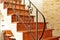 Wooden interior stairway with ornamental ironwork railing