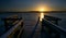 Wooden jetty with benches on a frozen lake in the light of the golden rising sun, beautiful landscape scenery, concept for a new