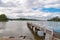 Wooden jetty with distant view of houses over water