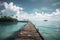 Wooden jetty in tropical sea with palm trees and blue sky