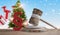 Wooden judge gavel with red paragraph in front of blurred Christmas presents and decorated fir 3d-illustration