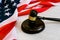 Wooden judge gavel and soundboard laying over US flag. Hammer and gavel. American law and justice concept. bidding