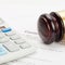 Wooden judge\'s gavel and neat calculator over contract - close up shot