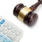 Wooden judge\'s gavel next to neat calculator - close up shot