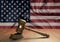 Wooden judge`s gavel Symbol of law and justice with the flag of USA. North American Supreme Court