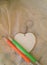 Wooden keychain like heart and two pencils.
