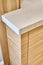 Wooden kitchen cupboard with acrylic solid surface countertop. Close-up