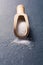 Wooden Kitchen Scoop With White Grain Salt On Slate Stone, Front View