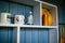 Wooden kitchen shelf on blue wooden wall. Transparent coffee container