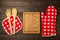 Wooden kitchen utensils, cutting board, potholder and glove on the table.