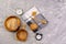 Wooden kitchen utensils objects on a concrete background with a clock
