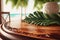 Wooden lacquered round table with a large tropical monstera leaf and a vase against a backdrop of a tropical beach.