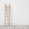 Wooden ladder on white wall with vintage wooden floor, background