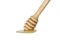 Wooden ladle with honey stands on a white isolated background.