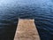 Wooden lake pier with dark water in background