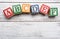 Wooden letter blocks on a white distressed wood background