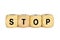 Wooden letter dice forming the word `Stop` on white background