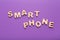 Wooden letters spelling Smartphone on violet background