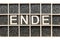 Wooden letters word ENDE in a box