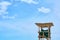 Wooden lifeguard tower against a blue sky.