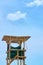 Wooden lifeguard tower against a blue sky.